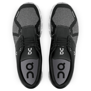 A pair of black athletic shoes with white soles viewed from above.