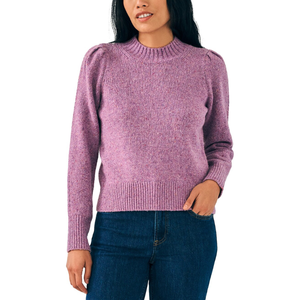A woman is wearing a long-sleeved purple sweater with a ribbed crew neck and cuffs, paired with dark jeans.