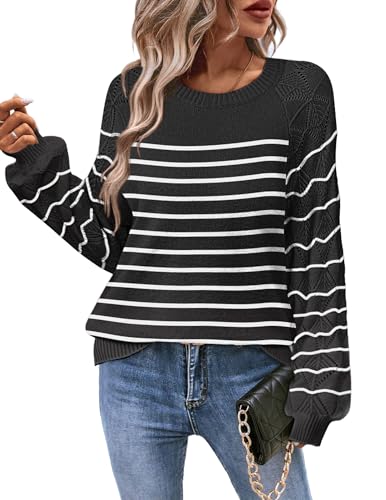 This is a black and white striped women's sweater with wavy patterns on the sleeves and perforated detailing on the shoulders. The sweater has a crew neck and ribbed cuffs and hem.