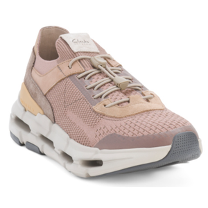 Clarks Suede Knit Sport Sneakers feature a light pink knit upper with suede accents, a cushioned sole with a unique cut-out design, and a toggle lacing system for adjustable fit.