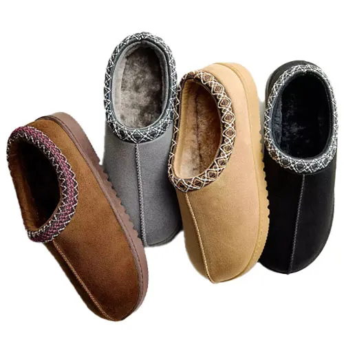 Four pairs of fleece-lined slippers in brown, gray, tan, and black, each featuring a decorative stitched pattern around the opening.