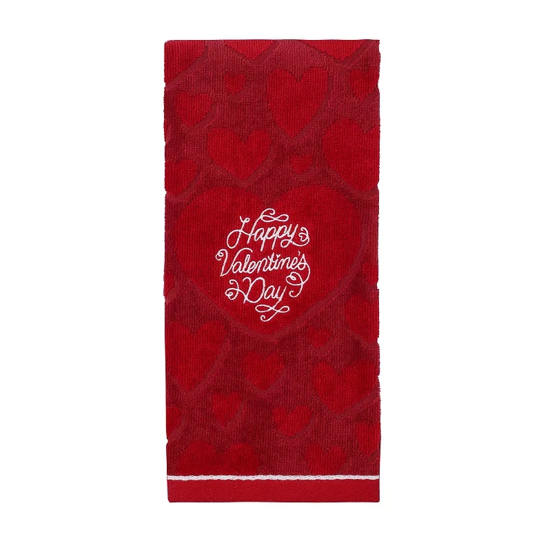 Red hand towel with a pattern of hearts and the phrase \“Happy Valentine's Day\“ embroidered in the center.