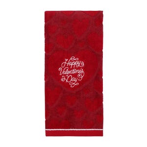 Red hand towel with a pattern of hearts and the phrase \“Happy Valentine's Day\“ embroidered in the center.
