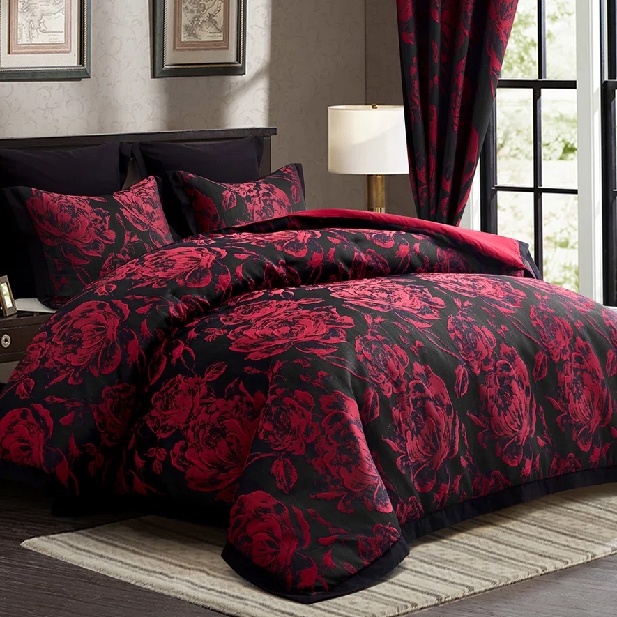 A black and red floral-patterned bedding set includes a comforter and pillow shams, with matching curtains in a bedroom setting.