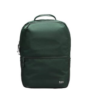 A dark green lululemon backpack with a minimalist design, featuring a top handle, two front zippered compartments, and subtle branding at the bottom.
