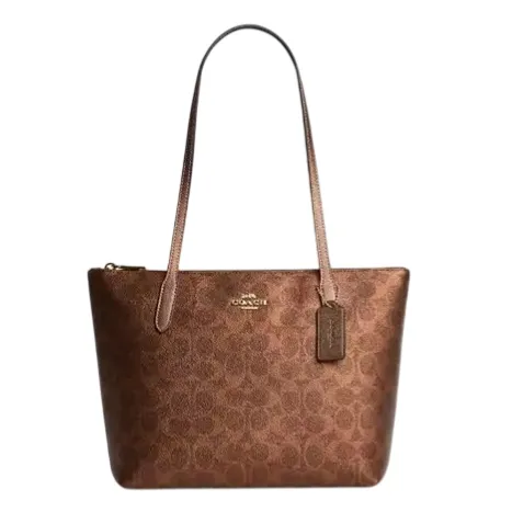 Brown Coach tote bag with signature logo pattern, featuring gold-tone hardware and long handles.