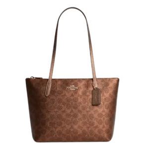 Brown Coach tote bag with signature logo pattern, featuring gold-tone hardware and long handles.