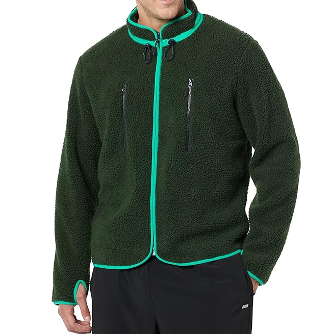 Dark green fleece jacket with bright green trim, featuring two zipper pockets on the chest. Worn with black pants.
