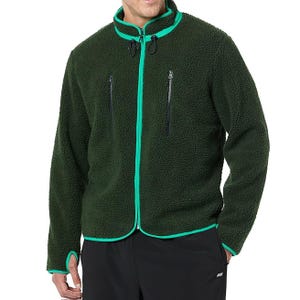 Dark green fleece jacket with bright green trim, featuring two zipper pockets on the chest. Worn with black pants.