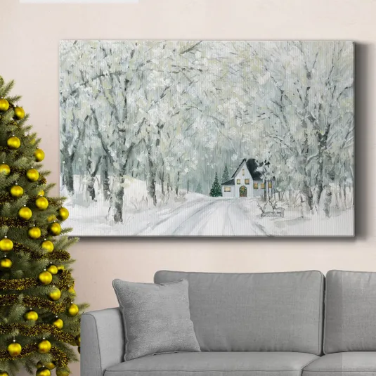 Canvas art depicting a snowy forest scene with a house surrounded by trees, hung above a gray sofa. A decorated Christmas tree with gold baubles stands nearby.