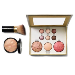 Makeup collection featuring a palette with multiple blush and highlighter shades, a standalone compact blush, and a kabuki brush.