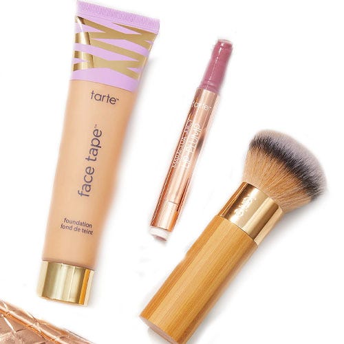 Tarte cosmetics featuring Face Tape foundation, a creaseless concealer in a tube, and a bamboo-handled makeup brush.