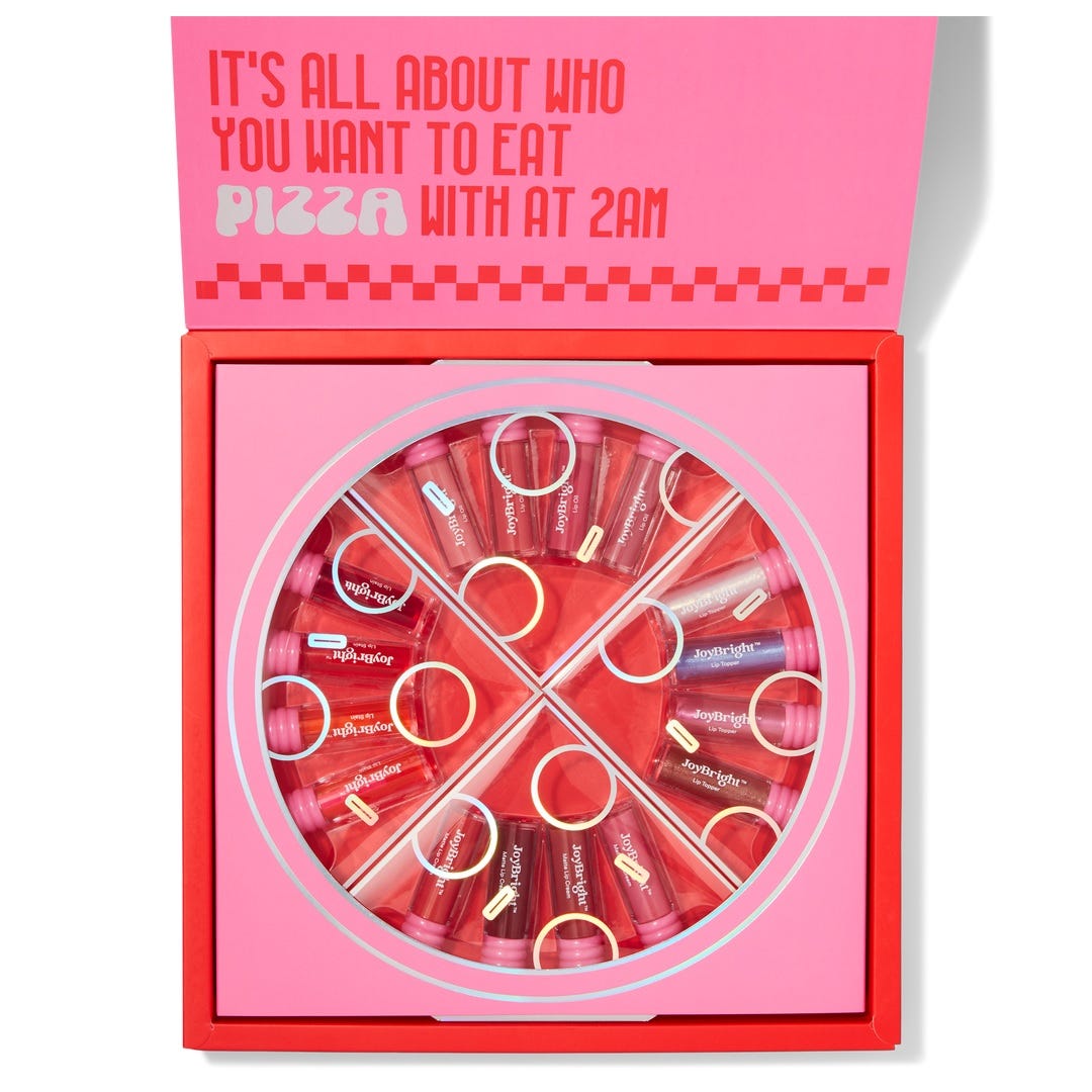 The Ulta Beauty Pizza Party Lip Set features 16 lip glosses arranged in a pizza-themed box, with shades varying from pinks to reds. The packaging includes playful text about late-night pizza.