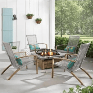 A patio set with four woven chairs and a central fire pit table.