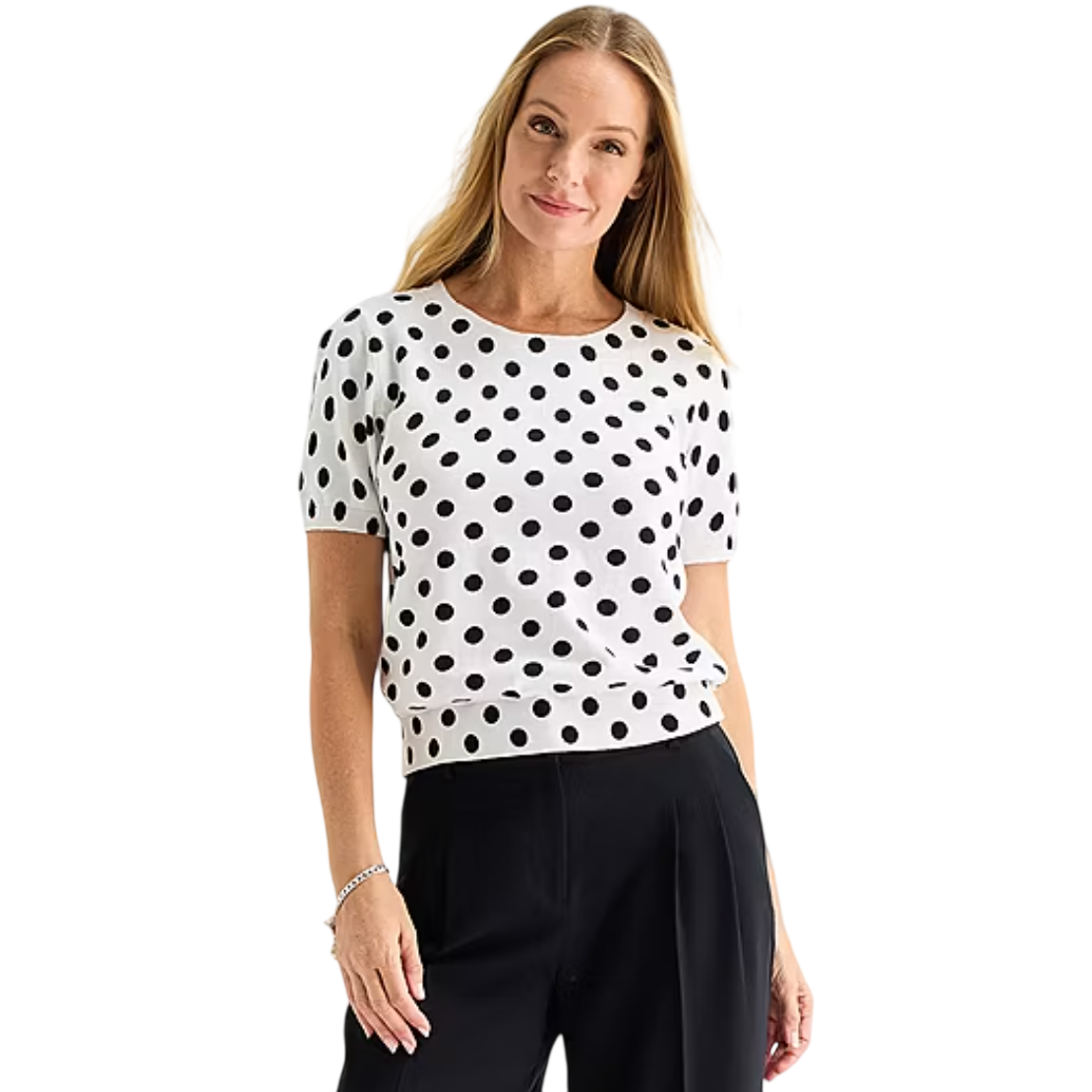 A person is wearing a white, short-sleeved top with black polka dots and black pants.