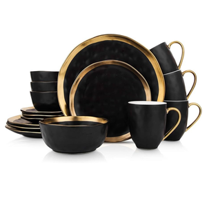 A black and gold dinnerware set featuring plates, bowls, and mugs.