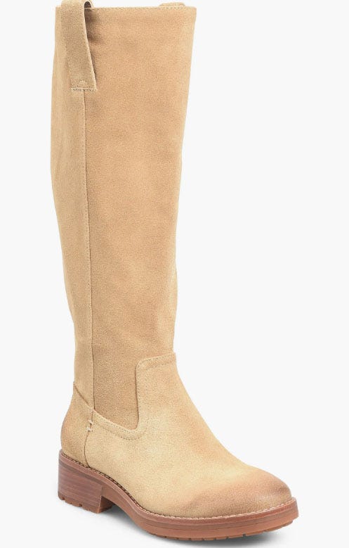 A tan suede knee-high boot with a low stacked heel and a lug sole, featuring a side pull tab for easy wear.