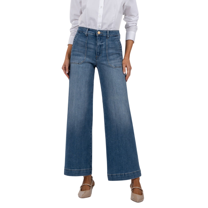 Wide-leg denim jeans with front pockets and a high waist, paired with a white button-up shirt and beige heels.