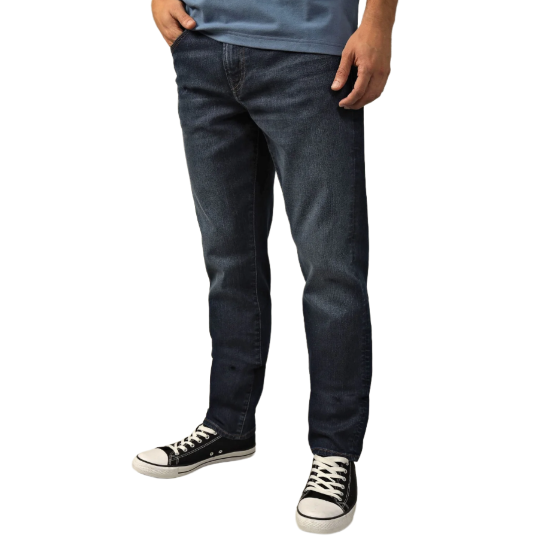 Dark blue jeans paired with black and white canvas sneakers, and a blue shirt visible at the top.