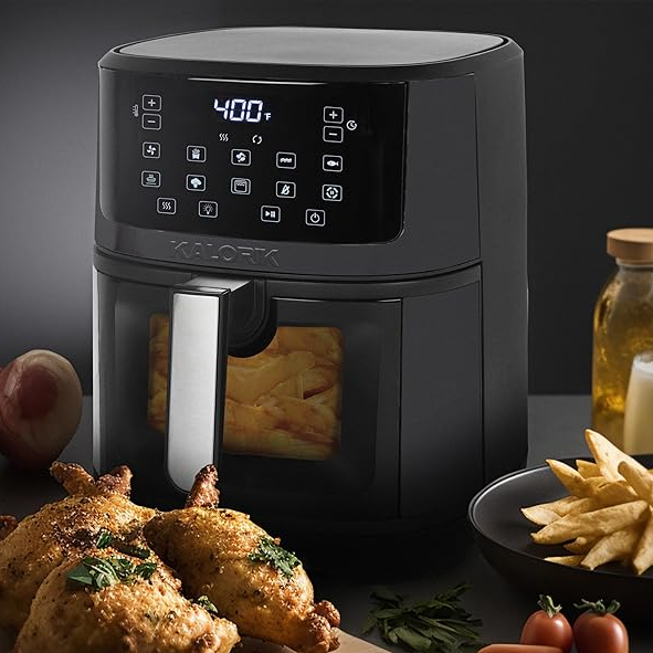 A black 7qt Kalorik Air Fryer with a digital touch screen displaying 400°F, accompanied by roast chicken and fries.