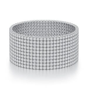 A wide, silver-toned bracelet featuring a grid design with small, square embellishments covering its surface.