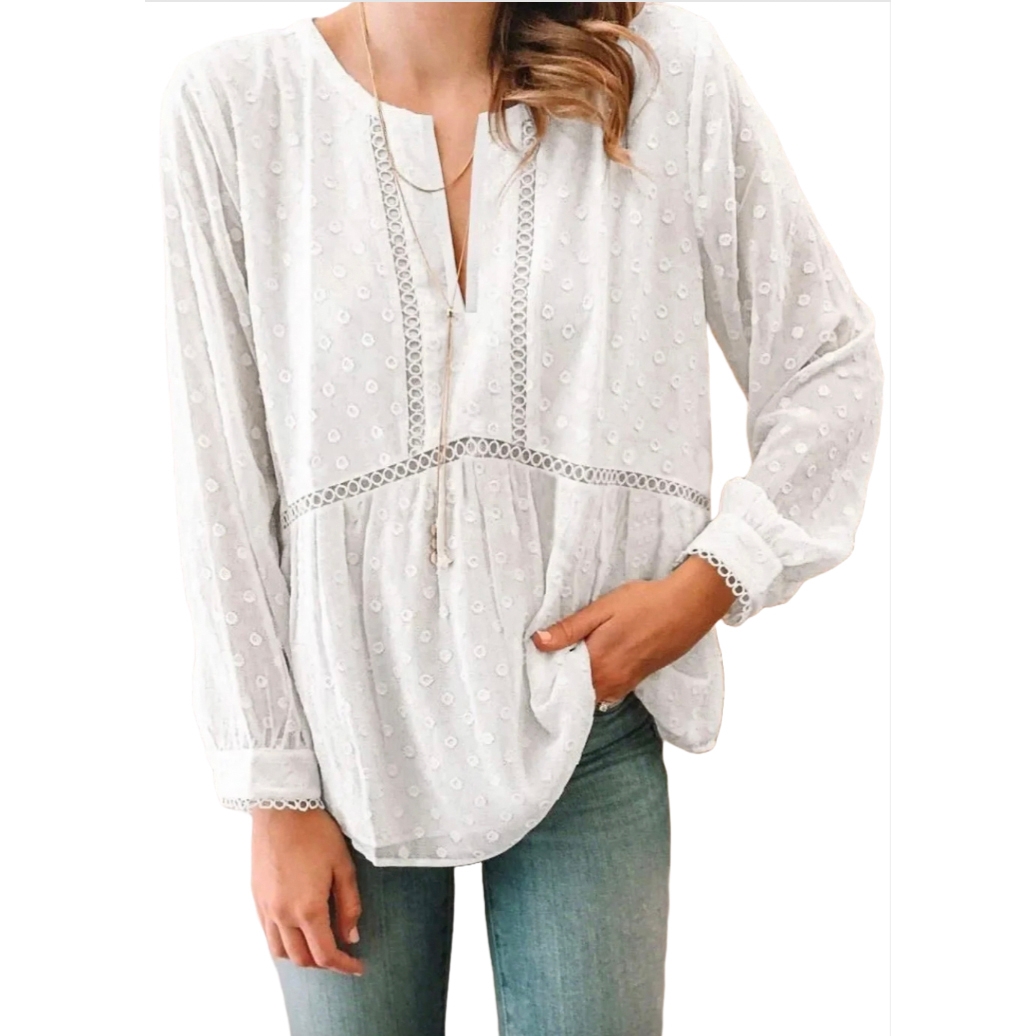 White long-sleeve blouse with a subtle dotted pattern and lace trim along the V-neckline and midsection. Features a relaxed fit with gathered detailing below the waist and around the cuffs, paired with light blue jeans.