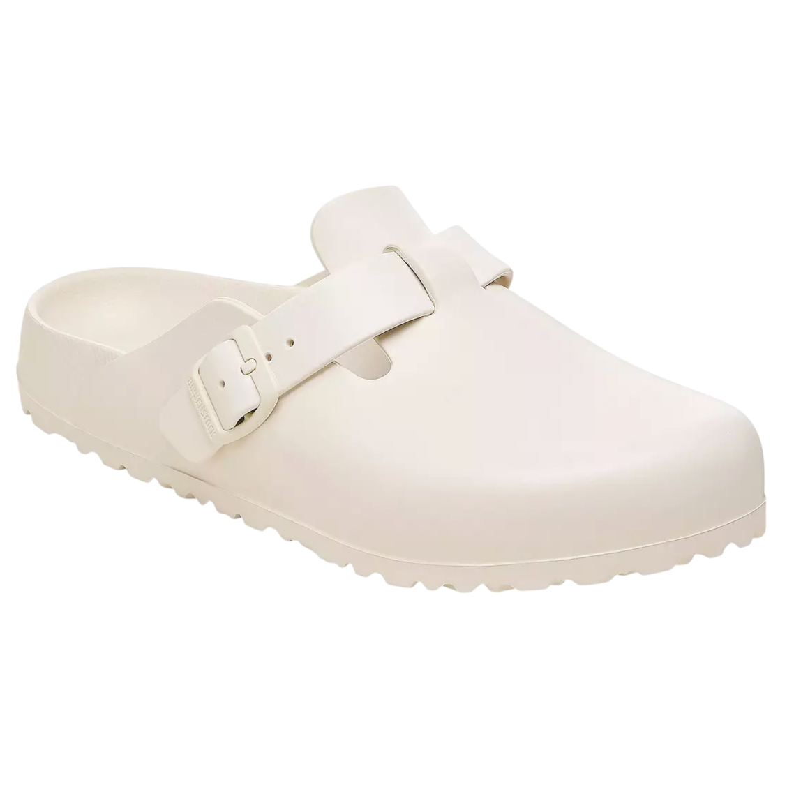A cream-colored clog sandal with a buckle strap and textured sole, designed for casual wear.