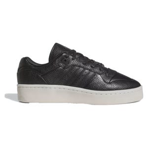 Adidas Rivalry Lux Low Shoes feature a black textured leather upper with subtle embossed stripes and a cream-colored platform sole, creating a stylish and modern look.