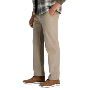 A person is wearing beige chinos paired with brown casual shoes and a plaid shirt layered over a green top.