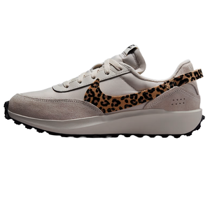 A beige sneaker with a leopard print swoosh, featuring suede and textile materials, and a rugged black outsole.