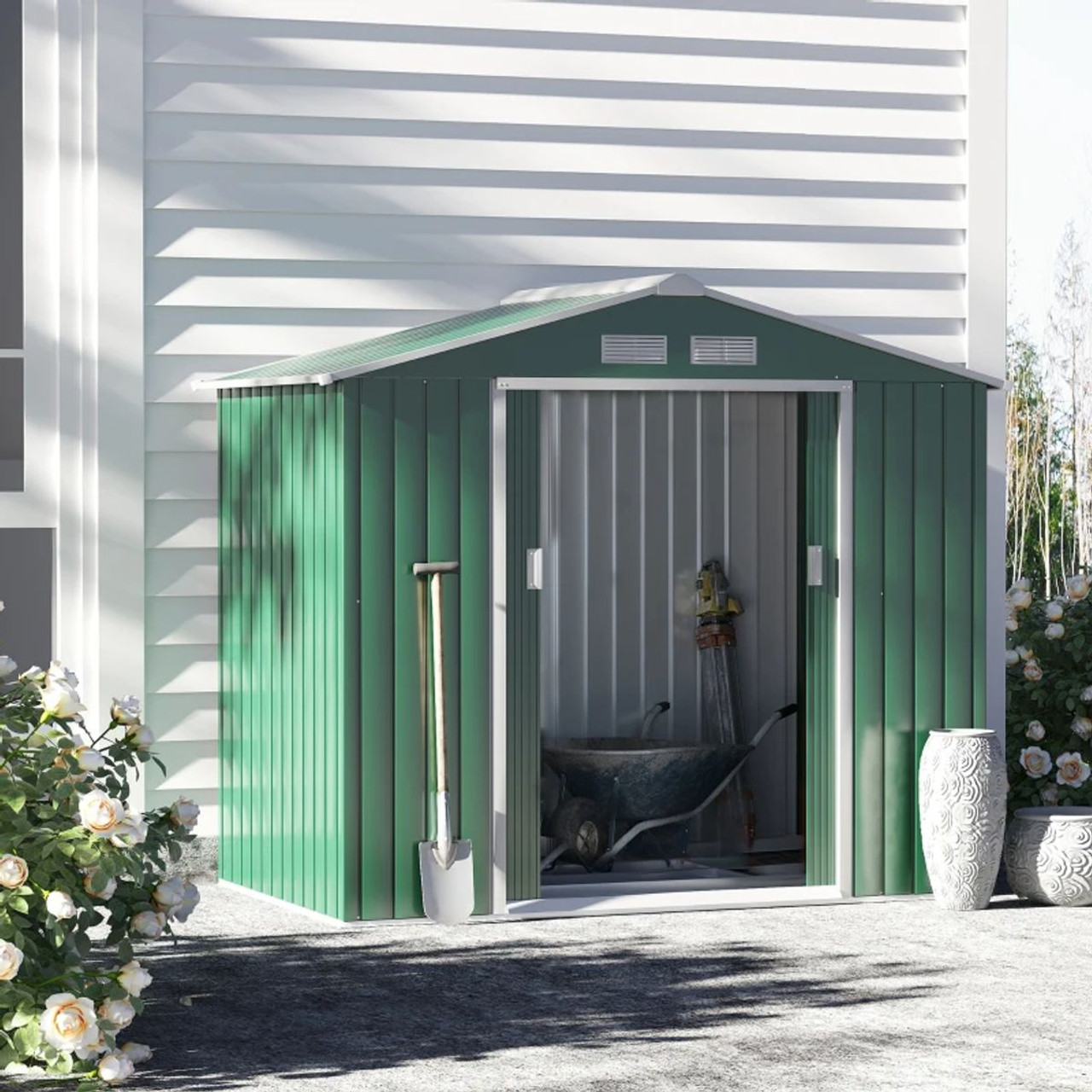 A metal garden shed with a sliding door, showcasing a wheelbarrow and gardening tools inside.