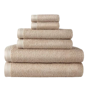 A set of beige towels in various sizes is neatly stacked, ranging from small hand towels to larger bath towels.