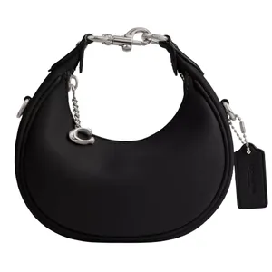 A black crescent-shaped handbag featuring silver hardware, a chain strap, and a small tag.