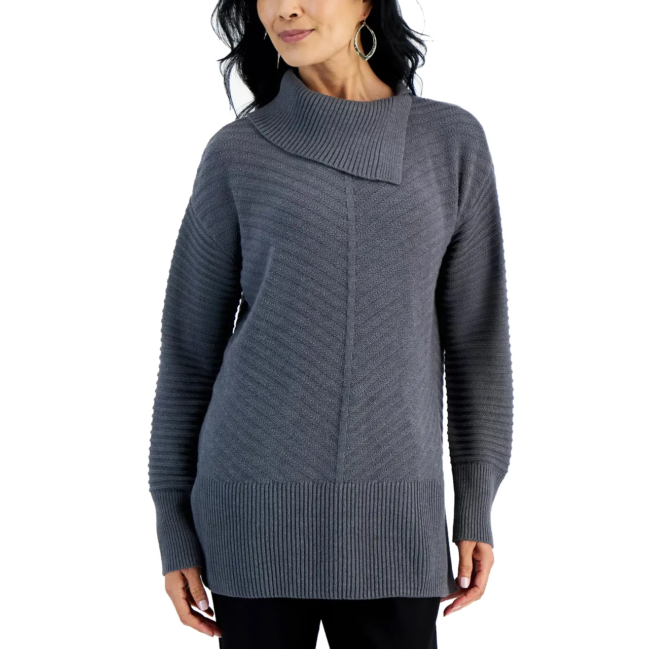 A woman is wearing a gray knit sweater with an asymmetric collar and ribbed detailing on the sleeves and hem, paired with black pants.