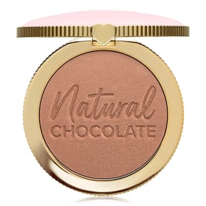 A bronzer compact with \“Natural Chocolate\“ embossed on the product, featuring a gold case with a heart-shaped clasp and a pink top.