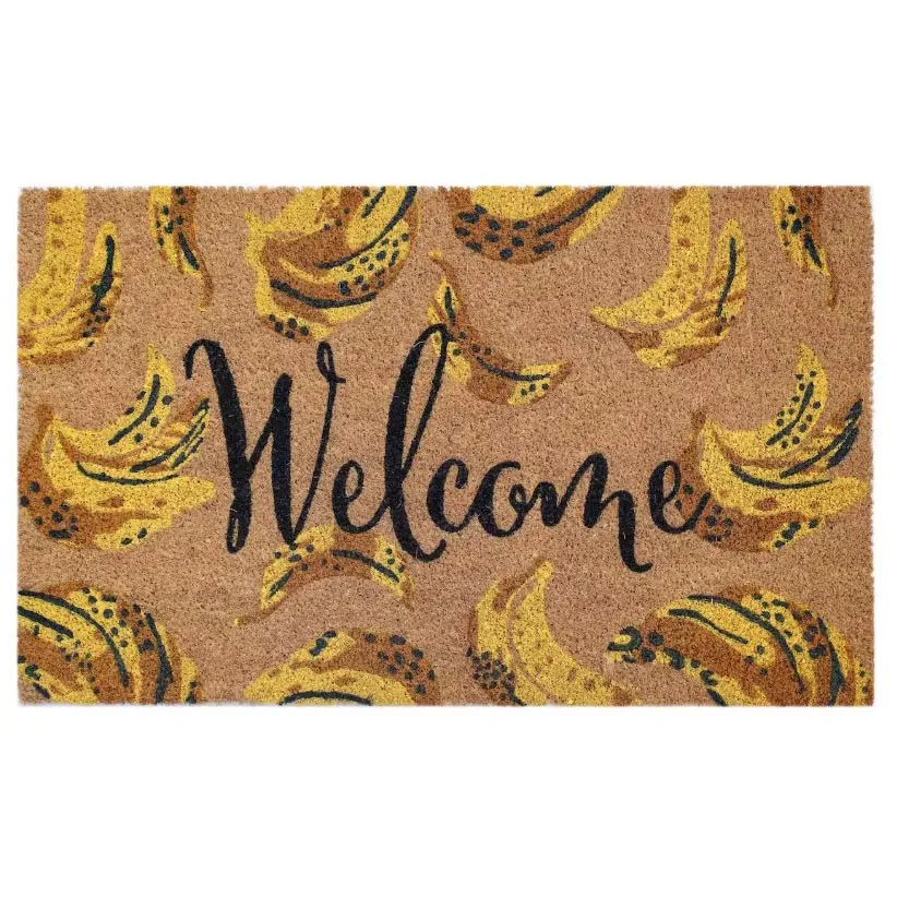 A doormat with the word \“Welcome\“ in black script and a pattern of yellow and black bananas on a tan background.