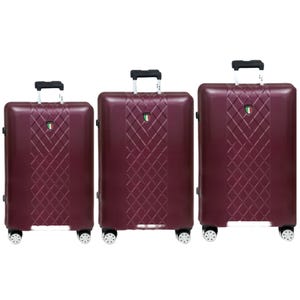 Three pieces of matching burgundy hard-shell luggage with a diamond pattern, each varying in size with retractable handles and wheels.