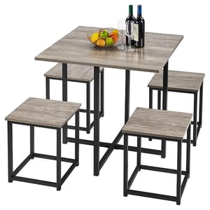 A 5-piece dining table set with a square wooden tabletop and four matching stools. The table and stools have black metal frames, and the table is topped with a bowl of fruit and two bottles of wine with glasses.