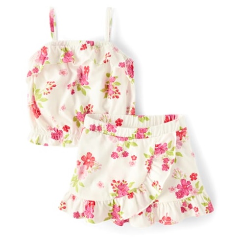 A sleeveless floral top with matching shorts, featuring pink and green flowers on a white background, both with ruffled edges.