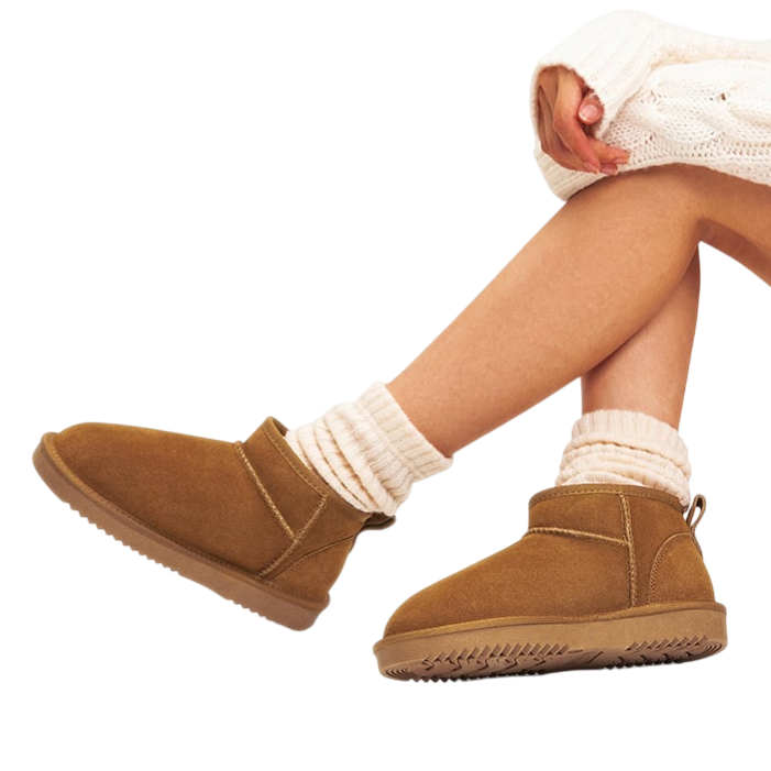 Brown ankle-height suede boots with ribbed cream socks, paired with a cream knit sweater.