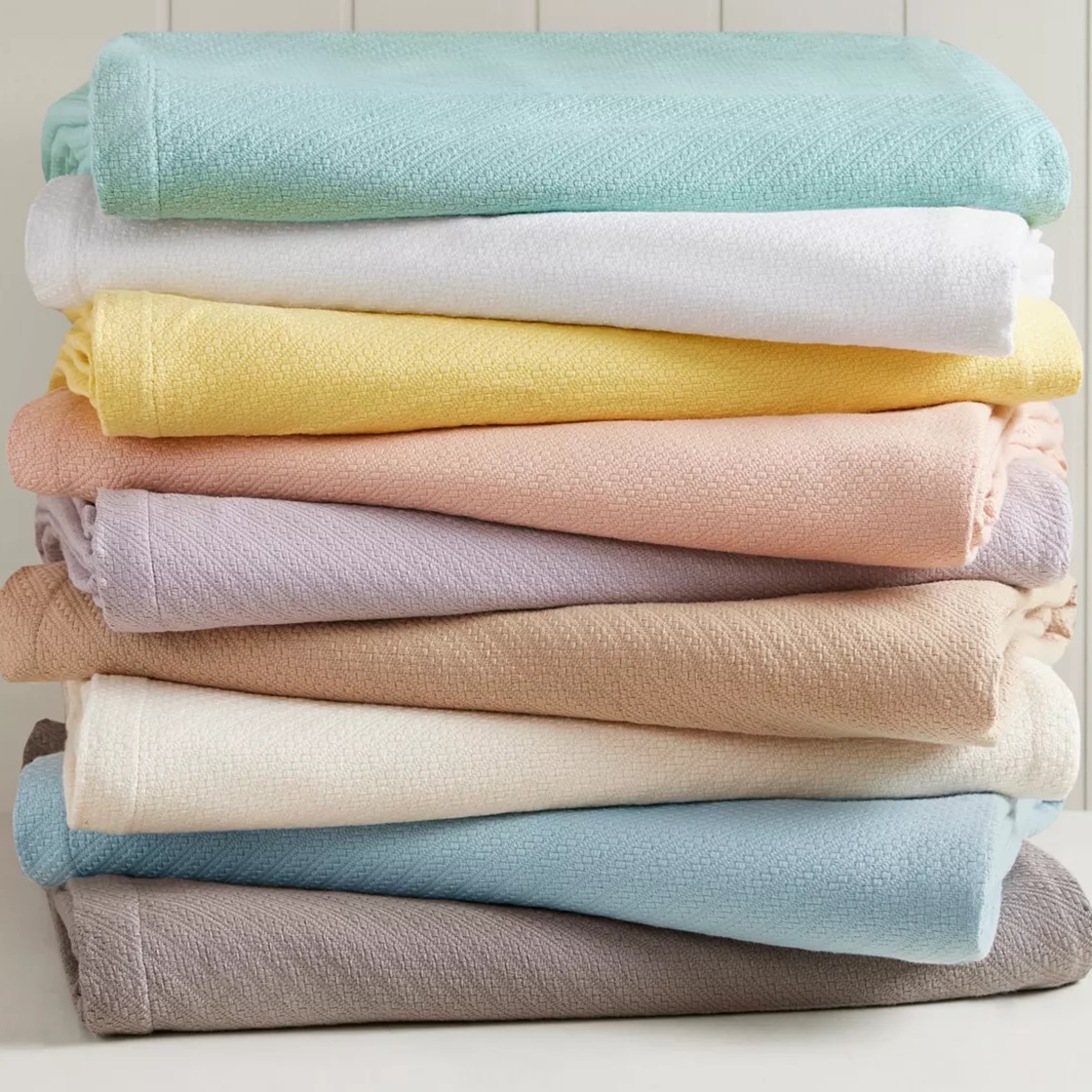 A stack of folded towels in various pastel colors.