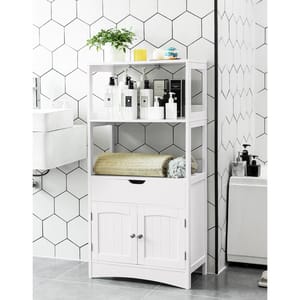 A white bathroom shelving unit with multiple levels holding towels, plants, and assorted toiletries.