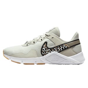 Nike Legend Training Shoes feature a light gray color with a leopard-patterned Nike swoosh, lightweight mesh upper, and a cushioned white sole with light brown accents for traction.