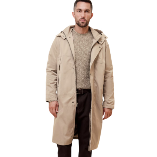 Beige long hooded anorak with a front zip closure and snap buttons, worn over a textured sweater and dark pants.