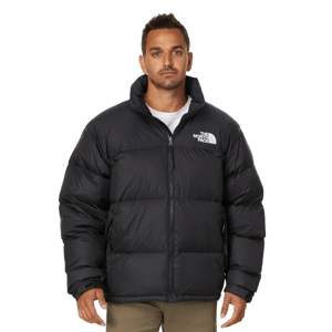 Man wearing a black The North Face puffer jacket with a front zipper, featuring logo embroidery on the upper front.