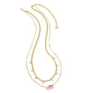 A layered gold necklace features a delicate chain with small pendants and a larger central pink stone accent, offering a stylish and versatile accessory.