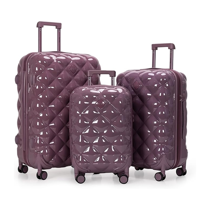 Three purple hardshell suitcases with a geometric diamond pattern design, featuring retractable handles and spinner wheels, varying in size from small to large.