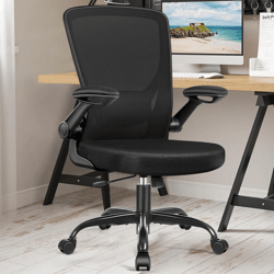 An ergonomic black office chair with adjustable armrests and a mesh backrest, positioned on a hardwood floor next to a desk with a computer monitor.