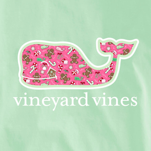 Vineyard Vines whale logo with a holiday theme, featuring gingerbread men, candy canes, and gingerbread houses on a pink pattern, set against a light green background.