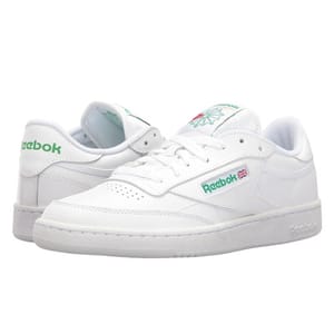 Reebok Vintage Club C Shoes in white feature a classic low-top design with green branding accents, including the Reebok logo and a Union Jack flag on the side. They have a perforated toe box and a clean, minimalistic look.